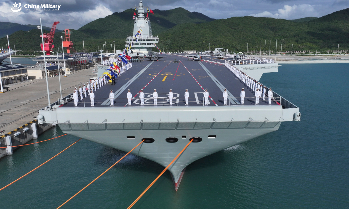 Marineros forman las bordas durante la ceremonia de puesta en servicio y presentación de la bandera del Fujian (casco 18), el primer portaaviones chino equipado con catapultas electromagnéticas, en la provincia de Hainan, al sur de China, el 5 de noviembre de 2025. Foto: China Military Online