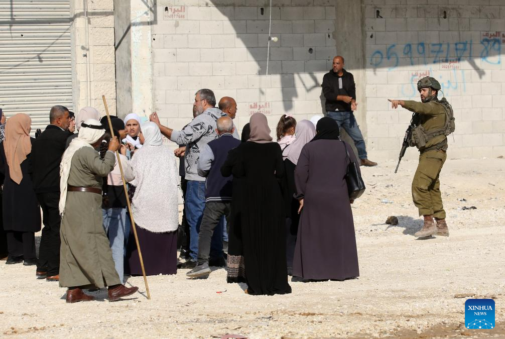 An Israeli soldier tries to prevent Palestinians from reaching their houses in Nur Shams refugee camp in the West Bank city of Tulkarm, Nov. 18, 2025. Palestinians took part in a demonstration demanding the right to return to their houses at the entrance of Nur Shams refugee camp, while Israeli soldiers assaulted the crowd and forced them to leave the area. (Photo by Nidal Eshtayeh/Xinhua)