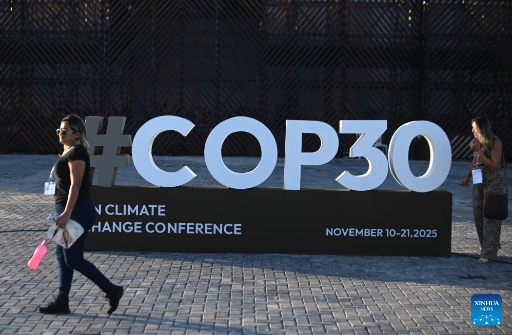 A woman walks past a logo of the upcoming 30th UN Climate Change Conference (COP30) in Belem, Brazil, Nov. 4, 2025. The COP30 will take place in the Amazon city of Belem from Nov. 10 to 21. (Photo by Lucio Tavora/Xinhua)