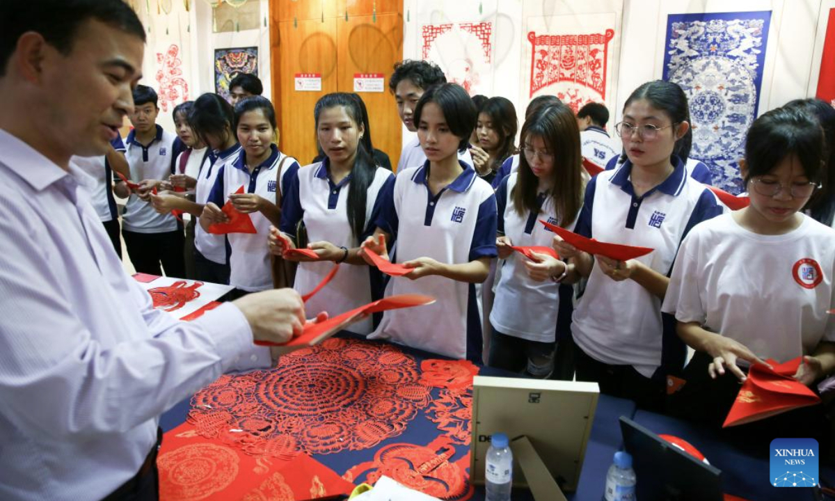 Students learn Chinese traditional paper-cutting during a traditional Chinese paper-cutting exhibition at the China Cultural Center in Yangon, Myanmar, Nov. 5, 2025. A traditional Chinese paper-cutting exhibition was held at the China Cultural Center in Yangon on Wednesday. (Xinhua/Myo Kyaw Soe)