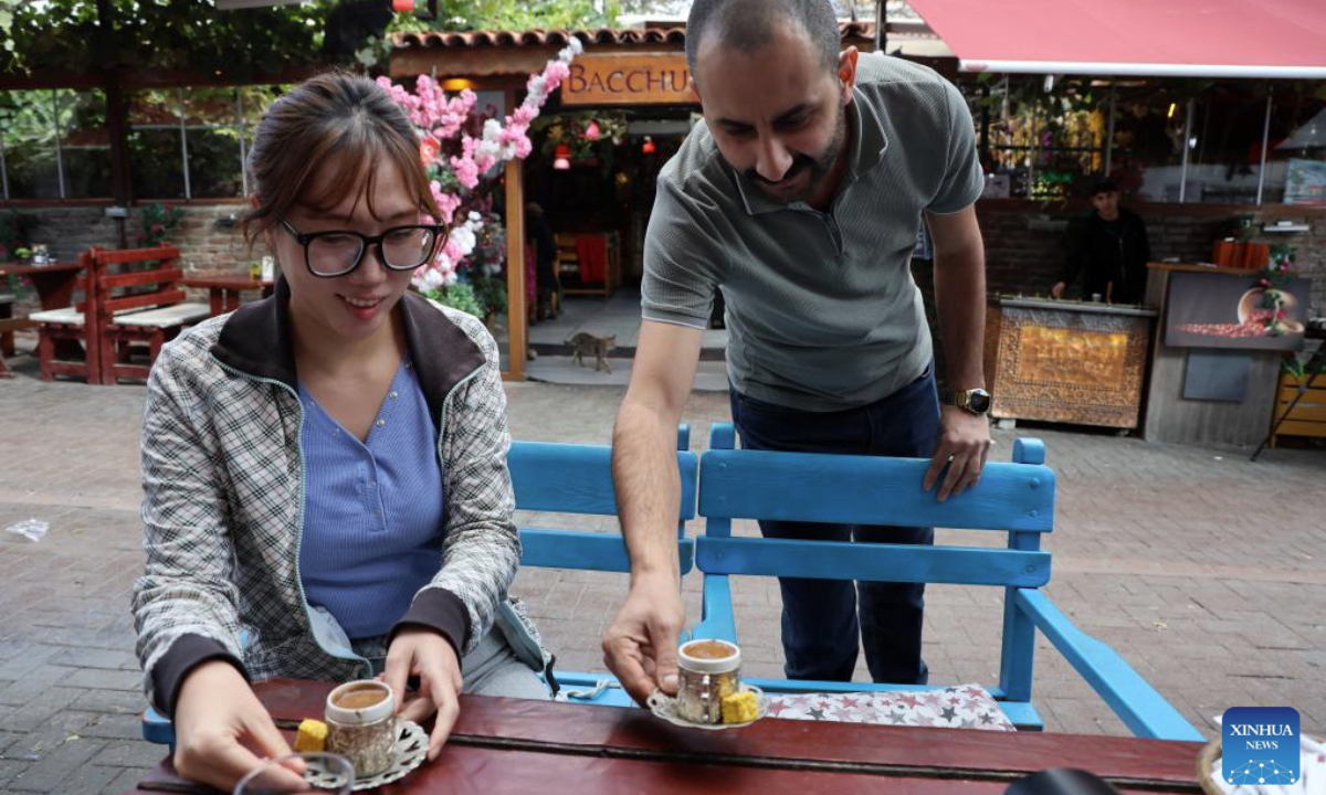 A barista serves sand-brewed coffee in Ankara, Türkiye, Nov. 12, 2025. The brewing process of Turkish sand coffee involves little coffee pots nestling in a bed of hot sand. (Mustafa Kaya/Handout via Xinhua)
