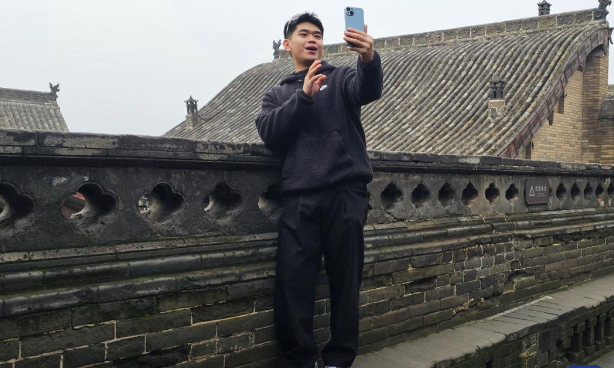 Veldesen Yaputra shoots a video at the Wang Family Courtyard in Lingshi County, north China's Shanxi Province, Oct. 16, 2025.(Xinhua/Li Yuanhao)