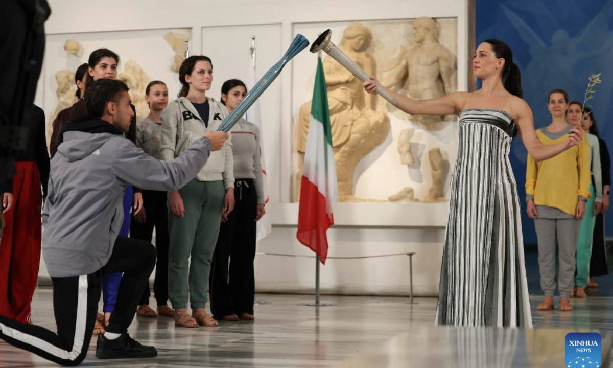 Actress Mary Mina (R, front), in the role of an ancient Greek High Priestess, performs with the first torchbearer, Greek rower Petros Gkaidatzis (L, front) during the rehearsal of the Olympic flame lighting ceremony for the Milan-Cortina 2026 Winter Olympic Games in Ancient Olympia, Greece, on Nov. 25, 2025. (Xinhua/Li Jing)