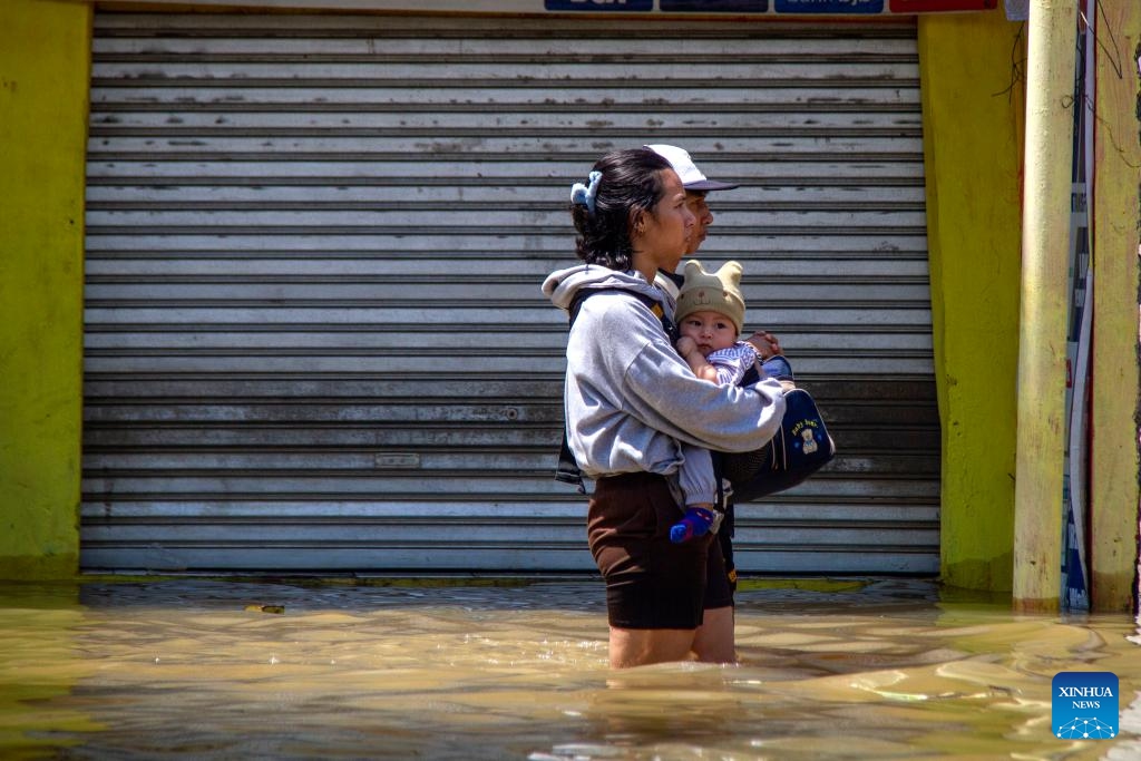 People wade through floodwater after heavy rain and overflow of Citarum river hit at Bojongsoang in Bandung, West Java, Indonesia, Nov. 1, 2025. (Photo: Xinhua)
