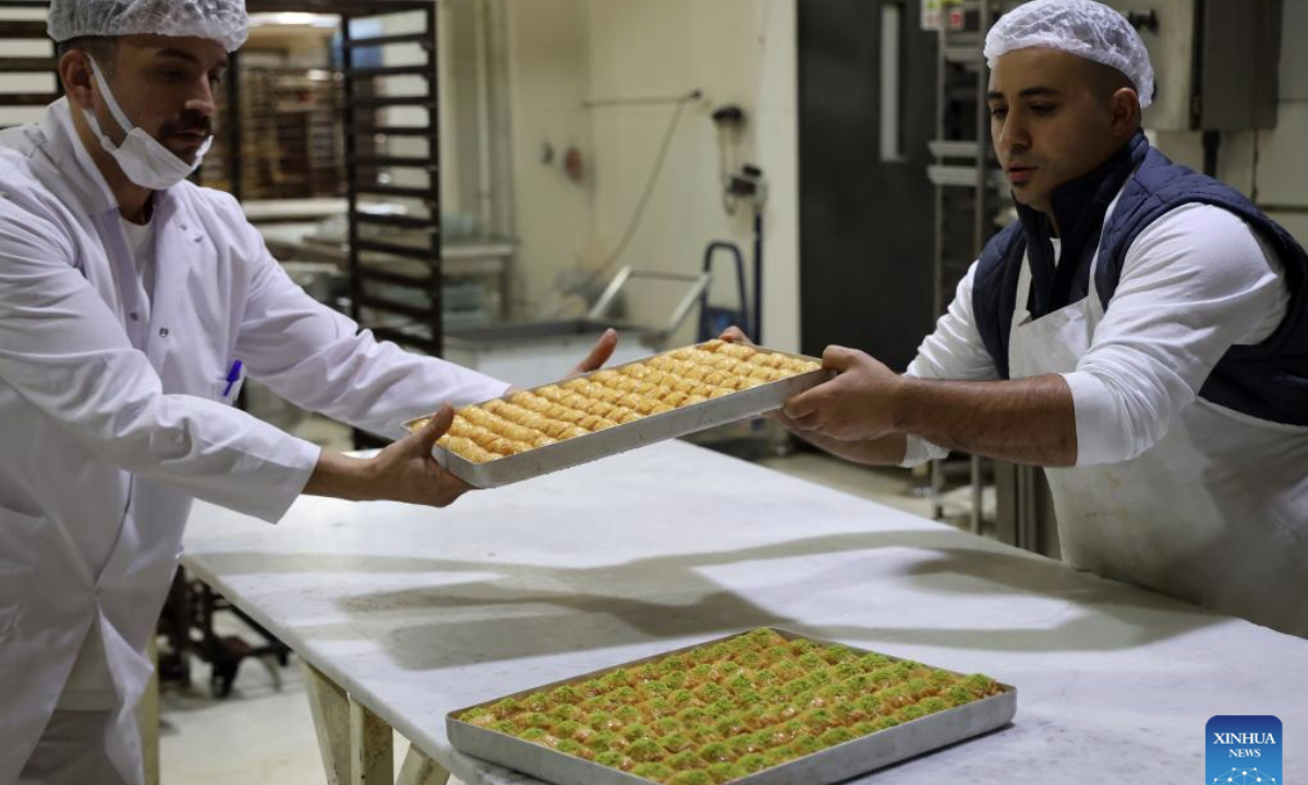 Bakers show the just-prepared baklavas, a traditional Turkish dessert, in Ankara, Türkiye, Nov. 14, 2025. Baklava is a sweet Turkish pastry with layers of filled dough, butter and the smell of sweet syrup. (Mustafa Kaya/Handout via Xinhua)