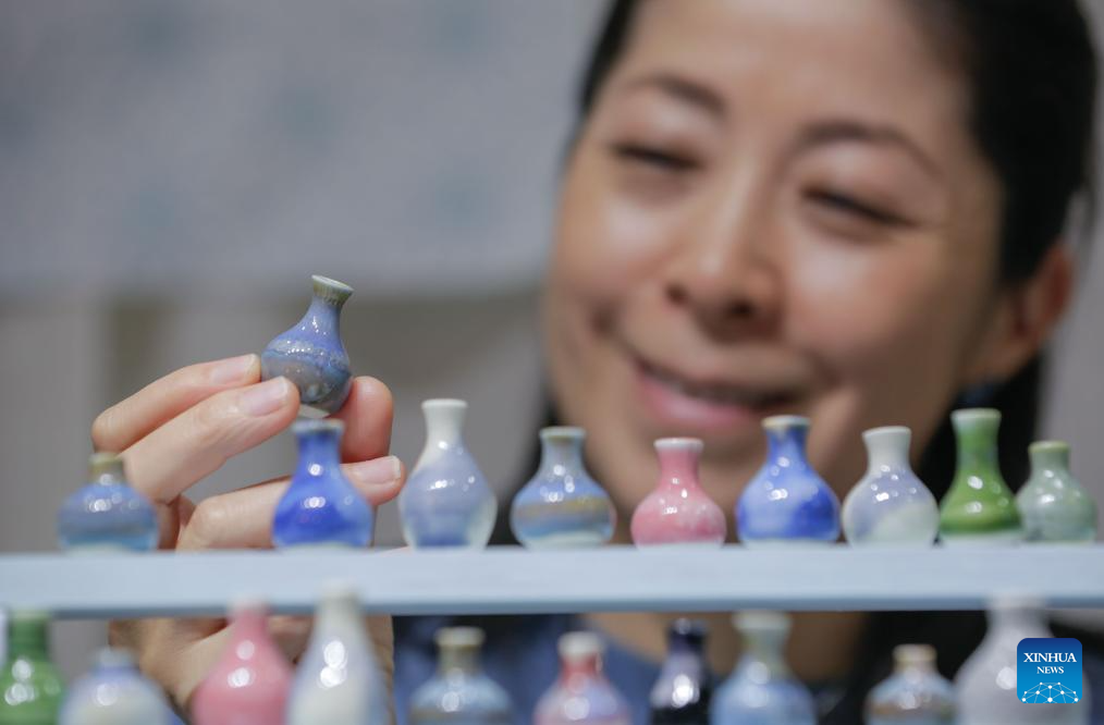 A woman views a small ceramic vase at the 2025 edition of the Circle Craft Holiday Market in Vancouver, British Columbia, Canada, Nov. 11, 2025. The 2025 edition of the Circle Craft Holiday Market kicked off here on Tuesday and runs until Nov. 16. (Photo by Liang Sen/Xinhua)