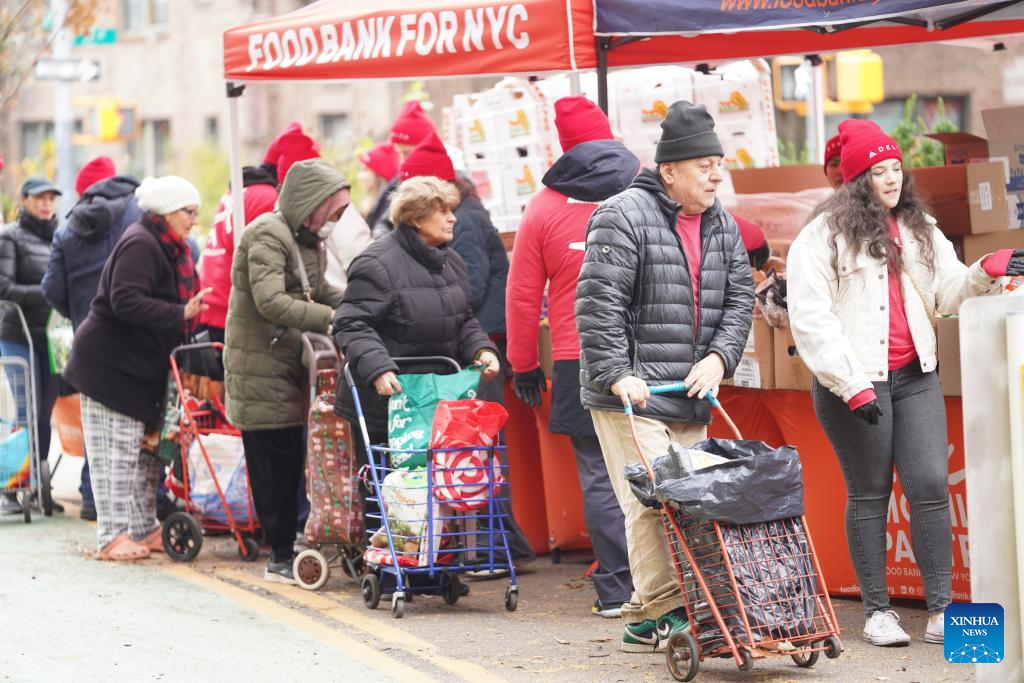 People line up to get free food items at a distribution station in New York, the United States, on Nov. 12, 2025. People received free food items from a distribution station of the Food Bank for New York city on Wednesday. (Xinhua/Zhang Fengguo)