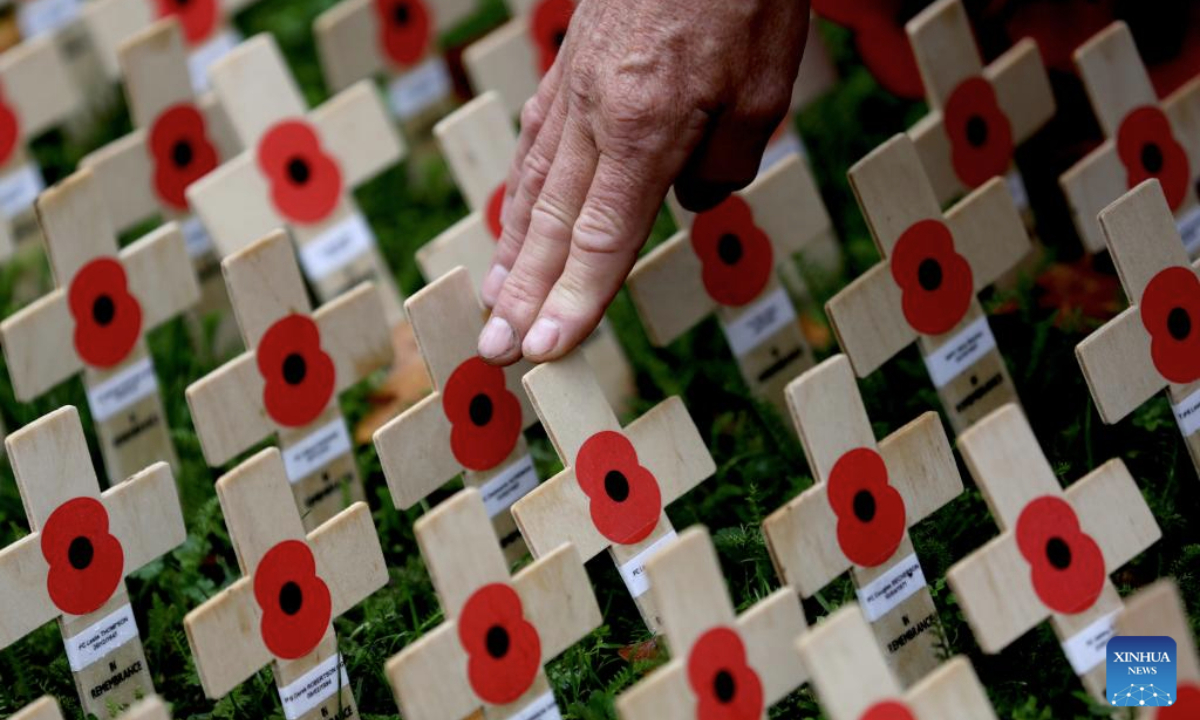 A man arranges poppy petals and crosses at the Field of Remembrance on the occasion of Remembrance Day at Westminster Abbey in London, Britain, Nov. 10, 2025. Remembrance Day is observed to remember the sacrifices made by soldiers during the WWI, which ended on Nov. 11, 1918. (Xinhua/Li Ying)