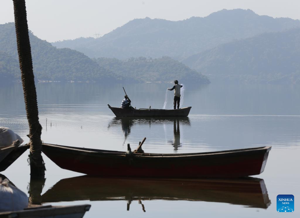 Fishermen cast their fishing net in Phangota Lake, in Pathankot district of India's northern Punjab state, Nov. 12, 2025. (Str/Xinhua)