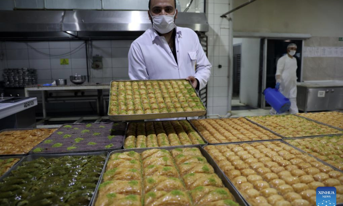 A baker shows the just-prepared baklavas, a traditional Turkish dessert, in Ankara, Türkiye, Nov. 14, 2025. Baklava is a sweet Turkish pastry with layers of filled dough, butter and the smell of sweet syrup. (Mustafa Kaya/Handout via Xinhua)