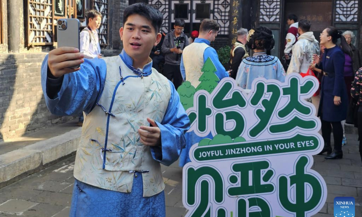 Veldesen Yaputra shoots a video at Rishengchang, China's first draft bank, in the ancient town of Pingyao in north China's Shanxi Province, Oct. 15, 2025.(Xinhua/Li Yuanhao)