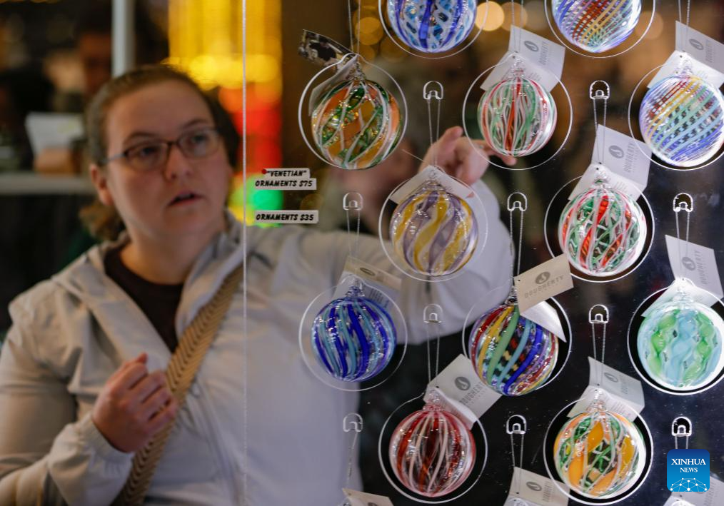A woman views glass ornaments at the 2025 edition of the Circle Craft Holiday Market in Vancouver, British Columbia, Canada, Nov. 11, 2025. The 2025 edition of the Circle Craft Holiday Market kicked off here on Tuesday and runs until Nov. 16. (Photo by Liang Sen/Xinhua)