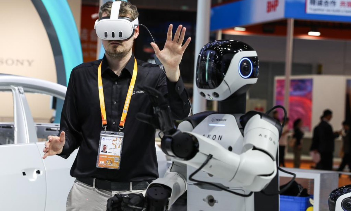 An exhibitor demonstrates a humanoid robot at the Intelligent Industry and Information Technology exhibition area during the eighth China International Import Expo in east China's Shanghai, Nov. 5, 2025. (Xinhua/Wang Jingqiang)