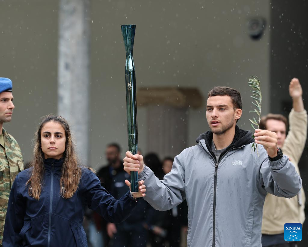 Greek rower Petros Gkaidatzis (R) , the first torchbearer, performs during the rehearsal of the Olympic flame lighting ceremony for the Milan-Cortina 2026 Winter Olympic Games in Ancient Olympia, Greece, on Nov. 25, 2025. (Xinhua/Li Jing)