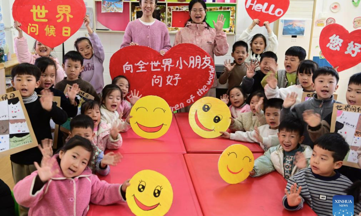 Teachers and children show emoji and greeting cards made to celebrate the upcoming World Hello Day, which falls on Nov. 21 annually, at a kindergarten in Qinyang, central China's Henan Province, Nov. 19, 2025. (Photo by Yang Fan/Xinhua)