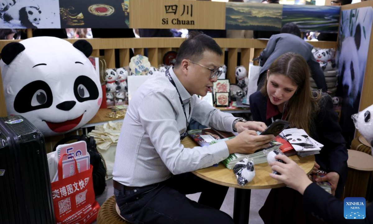 People talk at the China pavilion of the World Travel Market (WTM) London 2025 in London, Britain, Nov. 4, 2025. The WTM London 2025 opened on Tuesday, with the China pavilion drawing attention for its abundant tourism resources and cultural appeal. (Xinhua/Li Ying)