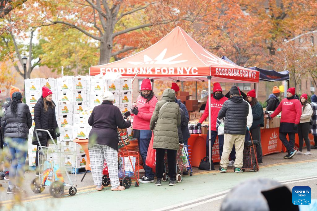 People line up to get free food items at a distribution station in New York, the United States, on Nov. 12, 2025. People received free food items from a distribution station of the Food Bank for New York city on Wednesday. (Xinhua/Zhang Fengguo)
