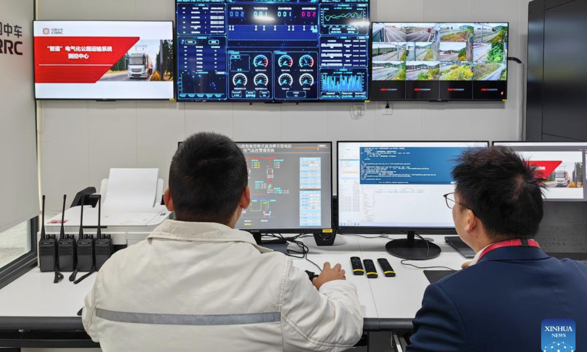 This photo taken with a mobile phone shows staff members monitoring the operation of the Zhidao Electrified Highway Transportation System at CRRC Zhuzhou Locomotive Co., Ltd. in Zhuzhou, central China's Hunan Province, Oct. 21, 2025. (Xinhua/Su Xiaozhou)