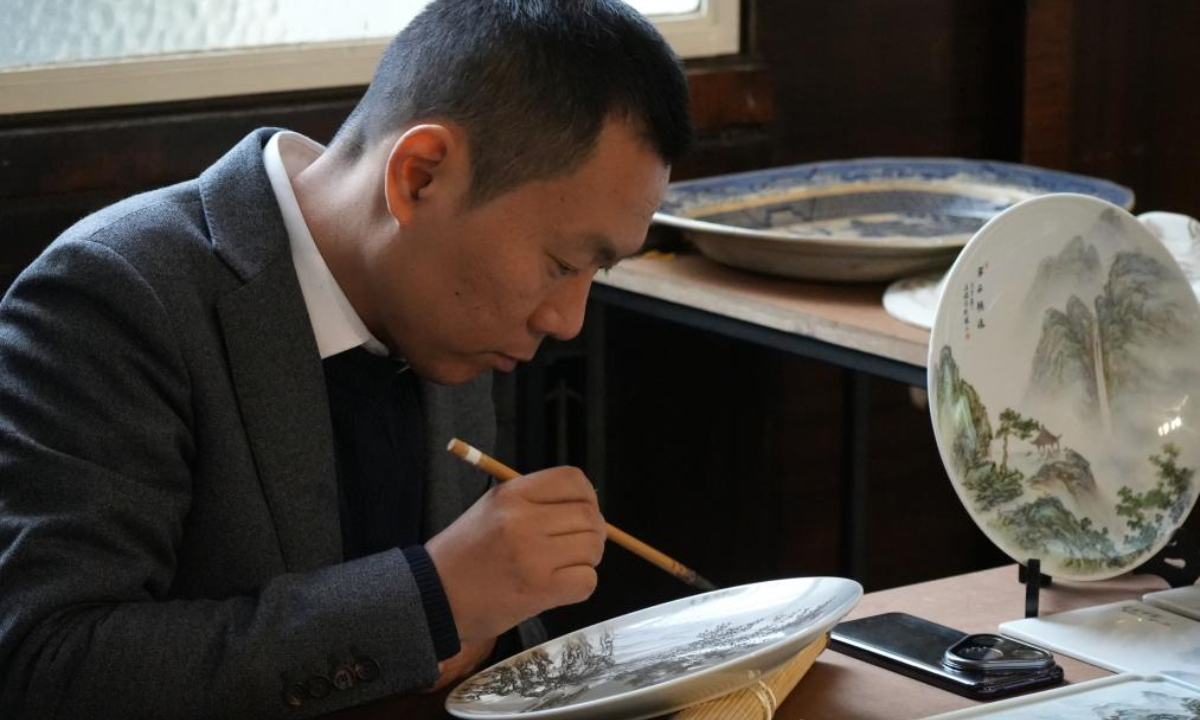 A faculty member from Jingdezhen Ceramic University demonstrates overglaze painting on the sidelines of an international ceramics symposium in Stoke-on-Trent, Britain, Nov. 22, 2025. (Xinhua/Zheng Bofei)



