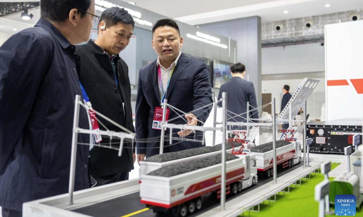 An exhibitor (3rd, L) introduces the Zhidao Electrified Highway Transportation System to visitors in Zhuzhou, central China's Hunan Province, Nov. 7, 2025. (Xinhua/Chen Sihan)