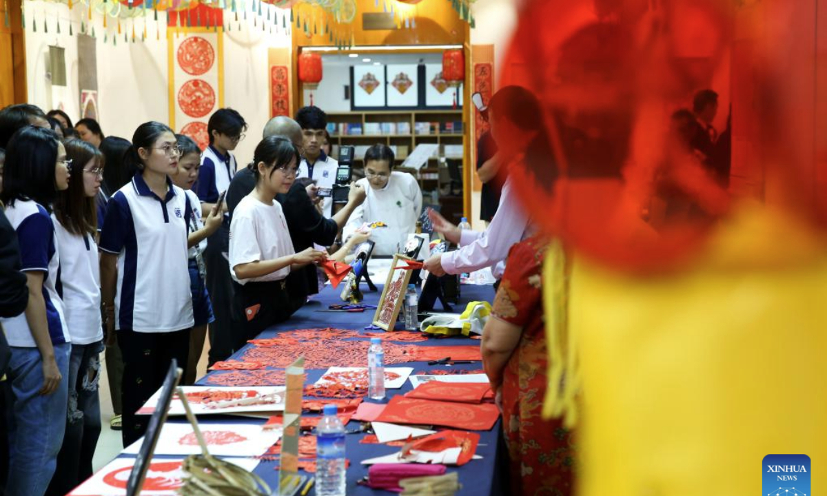 Students learn Chinese traditional paper-cutting during a traditional Chinese paper-cutting exhibition at the China Cultural Center in Yangon, Myanmar, Nov. 5, 2025. A traditional Chinese paper-cutting exhibition was held at the China Cultural Center in Yangon on Wednesday. (Xinhua/Myo Kyaw Soe)