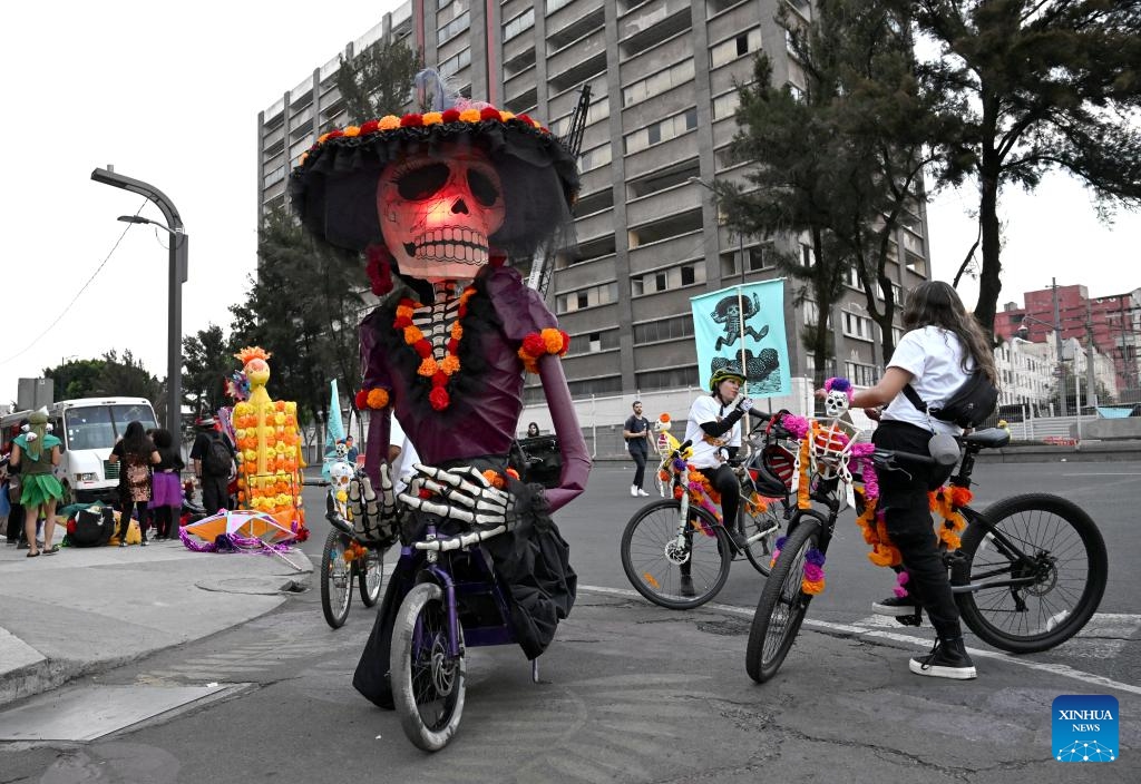 Participants take a rest by the street after the Day of the Dead Parade in downtown Mexico City, capital of Mexico, Nov. 1, 2025.(Photo: Xinhua)