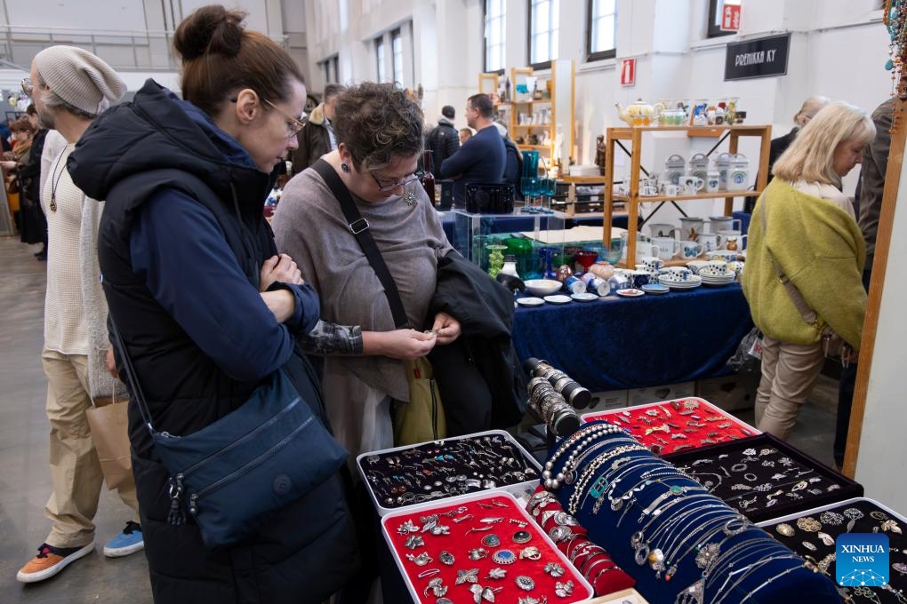 Visitors select items in an antique jewelry display case at the 2025 Helsinki Antique Fair in Helsinki, capital of Finland, on Nov. 1, 2025. The two-day fair opened here on Saturday. As one of the largest antique exhibitions and trading events in Finland, this year's fair brought together nearly 40 exhibitors from across the country and drew large crowds of collectors and visitors. (Photo: Xinhua)