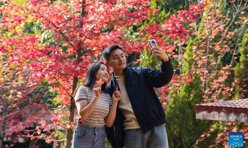 Visitors take selfies at Heilongtan Park in Kunming, southwest China's Yunnan Province, Nov. 1, 2025. (Photo: Xinhua)