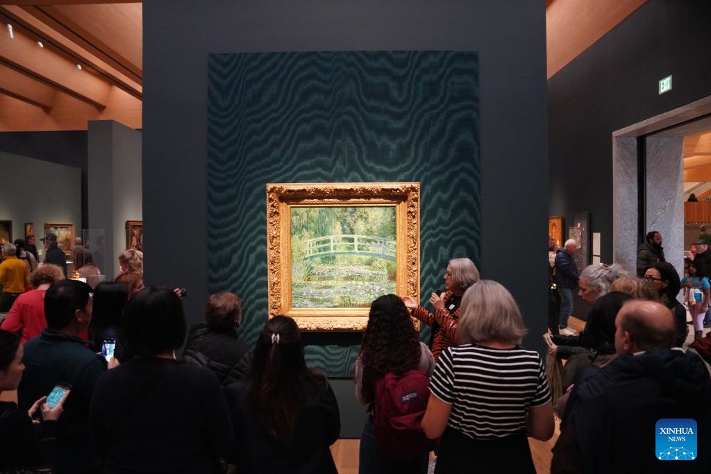 People listen to an introduction of the Water Lilies and Japanese Bridge by Claude Monet at the Princeton University Art Museum in New Jersey, the United States, on Nov. 1, 2025. After 13 years of design and construction, the new art museum of Princeton University reopened its doors to the general public with a 24-hour party from 5 p.m. Oct. 31, to 5 p.m. Nov. 1. (Photo: Xinhua)