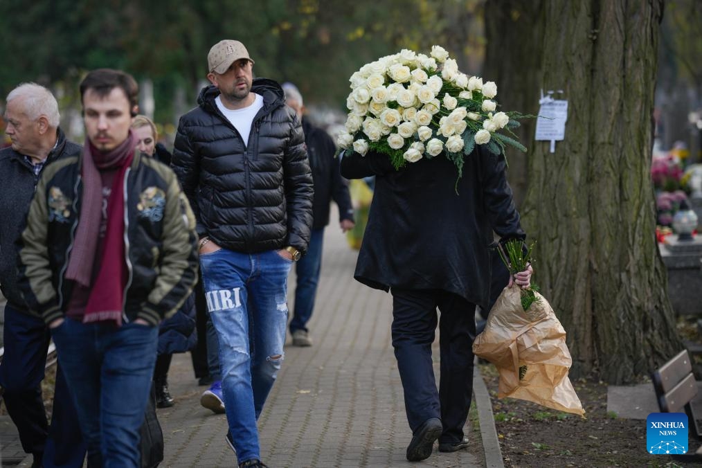 A man carries a large bouquet of white roses to commemorate All Saints' Day at a cemetery in Warsaw, Poland on Nov. 1, 2025. Saturday marks All Saints' Day in Poland, when people traditionally return home to reunite with family members and visit cemeteries to honor their ancestors. (Photo: Xinhua)