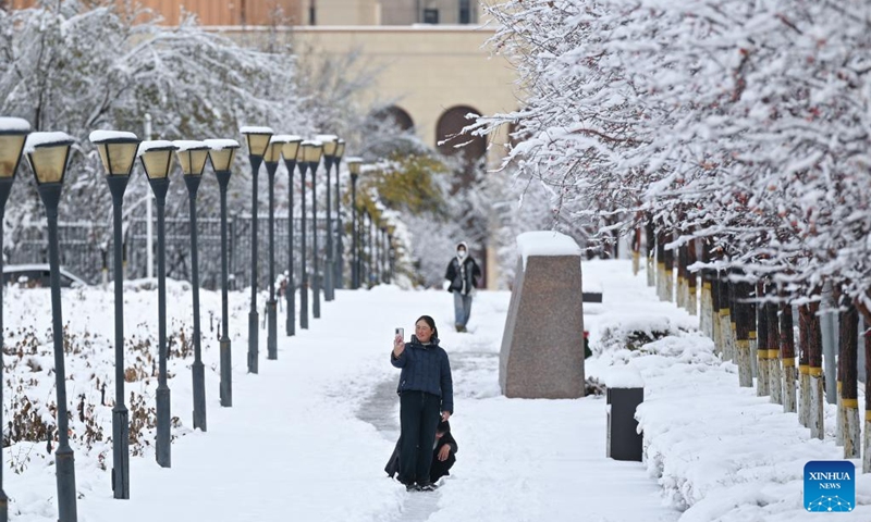 People walk on a street after snow in Urumqi, northwest China's Xinjiang Uygur Autonomous Region, Nov. 6, 2025. A blizzard has swept across many parts of northwest China's Xinjiang Uygur Autonomous Region since Wednesday, disrupting traffic in several areas and setting a new precipitation record in the regional capital, Urumqi. Photo: Xinhua