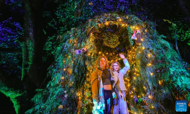 People walk along an illuminated woodland trail during a media preview of the Harry Potter: A Forbidden Forest Experience at Stanley Park in Vancouver, British Columbia, Canada, Nov. 6, 2025. The immersive outdoor event allows visitors to explore a themed trail inspired by the Forbidden Forest from the Harry Potter films. Through virtual reality effects and lighting installations, the woodland is transformed into a magical pathway featuring mystical creatures, interactive displays, and a themed village. The event made its Canadian debut in Vancouver on Nov. 7 and run until Dec. 7. Photo: Xinhua