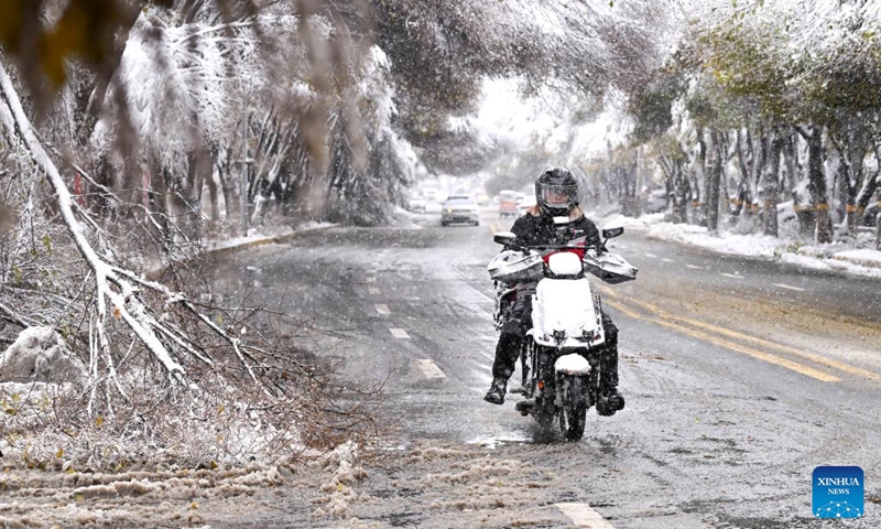 A deliveryman rides on a street after snow in Urumqi, northwest China's Xinjiang Uygur Autonomous Region, Nov. 6, 2025. A blizzard has swept across many parts of northwest China's Xinjiang Uygur Autonomous Region since Wednesday, disrupting traffic in several areas and setting a new precipitation record in the regional capital, Urumqi. Photo: Xinhua