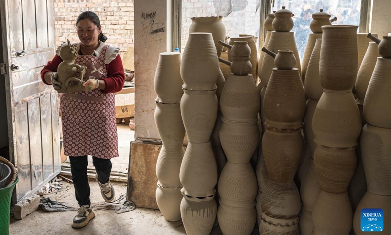 A villager transfers pottery products at a workshop in Liaohu Village of Qujing, southwest China's Yunnan Province, Nov. 5, 2025. Located on the bank of the Nanpan River in the city of Qujing, the Liaohu Village boasts a thousand-year pottery-making tradition. Photo: Xinhua