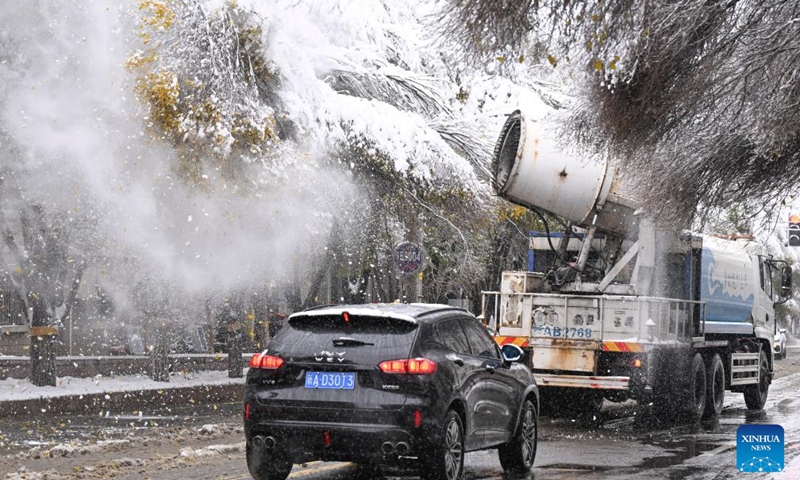 Sanitation workers use machinery to blow off snow which accumulated on treetops to prevent branches from breaking in Urumqi, northwest China's Xinjiang Uygur Autonomous Region, Nov. 6, 2025. A blizzard has swept across many parts of northwest China's Xinjiang Uygur Autonomous Region since Wednesday, disrupting traffic in several areas and setting a new precipitation record in the regional capital, Urumqi. Photo: Xinhua