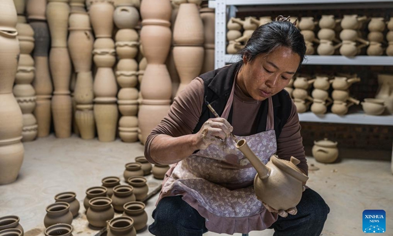 A villager makes a pottery product at a workshop in Liaohu Village of Qujing, southwest China's Yunnan Province, Nov. 5, 2025. Located on the bank of the Nanpan River in the city of Qujing, the Liaohu Village boasts a thousand-year pottery-making tradition. Photo: Xinhua