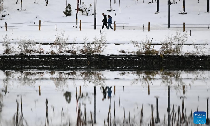 People visit a park after snow in Urumqi, northwest China's Xinjiang Uygur Autonomous Region, Nov. 6, 2025. A blizzard has swept across many parts of northwest China's Xinjiang Uygur Autonomous Region since Wednesday, disrupting traffic in several areas and setting a new precipitation record in the regional capital, Urumqi. Photo: Xinhua
