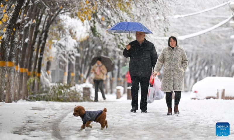 People walk on a street after snow in Urumqi, northwest China's Xinjiang Uygur Autonomous Region, Nov. 6, 2025. A blizzard has swept across many parts of northwest China's Xinjiang Uygur Autonomous Region since Wednesday, disrupting traffic in several areas and setting a new precipitation record in the regional capital, Urumqi. Photo: Xinhua