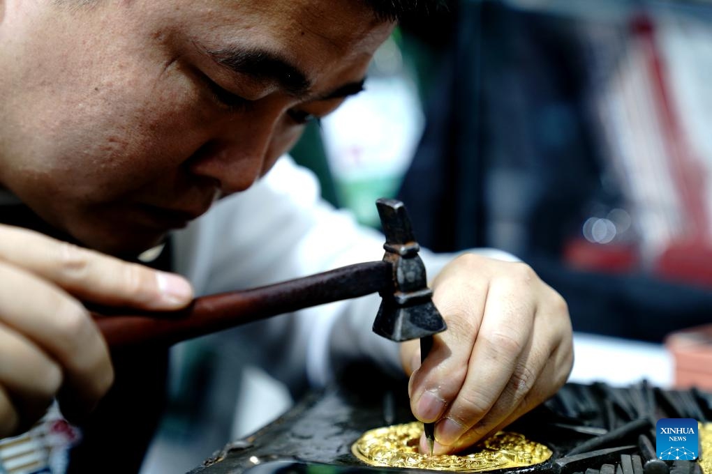 An artist makes golden decorations at the booth of China's Zhejiang Province during the eighth China International Import Expo (CIIE) in east China's Shanghai, Nov. 7, 2025. The CIIE is not only a global platform for the trade of goods and services but also a grand event for the exchange of cultures and ideas between China and the world. (Xinhua/Zhang Jiansong)