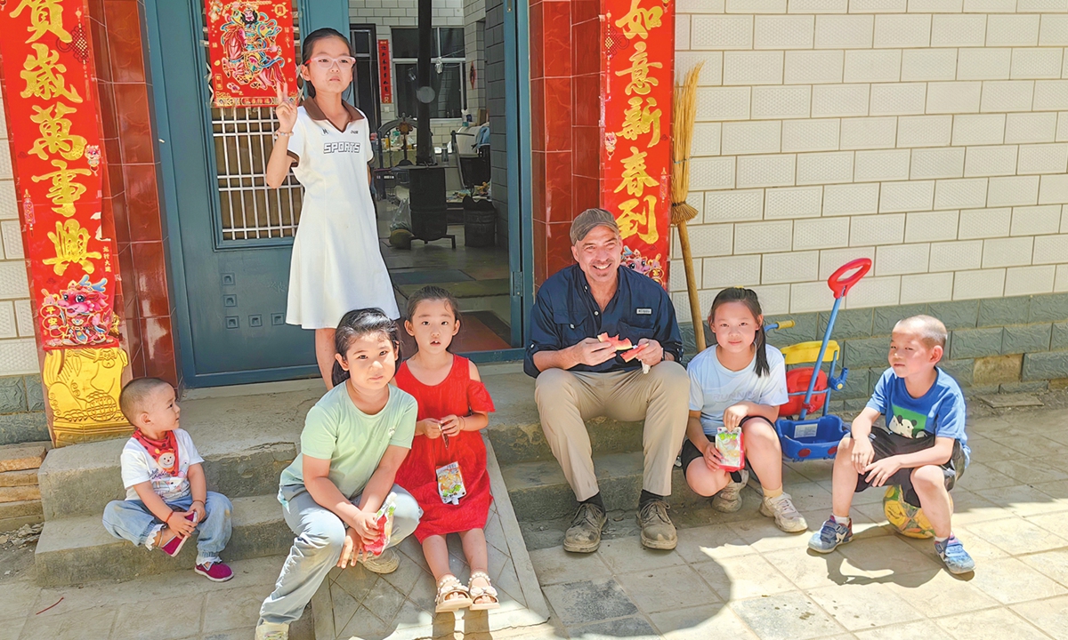 Neil Schmid poses for a photo with local children in Dunhuang, Northwest China's Gansu Province. Photo: Courtesy of Neil Schmid