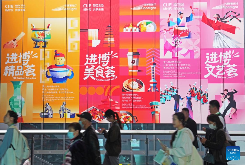 Visitors walk past posters during the eighth China International Import Expo (CIIE) in east China's Shanghai, Nov. 8, 2025. The CIIE is not only a global platform for the trade of goods and services but also a grand event for the exchange of cultures and ideas between China and the world. (Xinhua/Liu Ying)