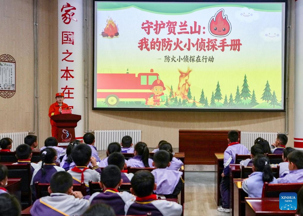 A staff member of Ningxia Helan Mountain National Nature Reserve Administration gives a lecture on forest fire prevention at a primary school in Yinchuan, northwest China's Ningxia Hui Autonomous Region, Nov. 7, 2025. Currently, the risk of forest fire is high across the Helan Mountain. Staff members of local nature reserve administration have rolled out a series of educational activities with the theme of forest fire prevention, aiming to enhance students' safety awareness via lectures, equipment demonstrations, and hands-on experiences. (Xinhua/Yang Zhisen)