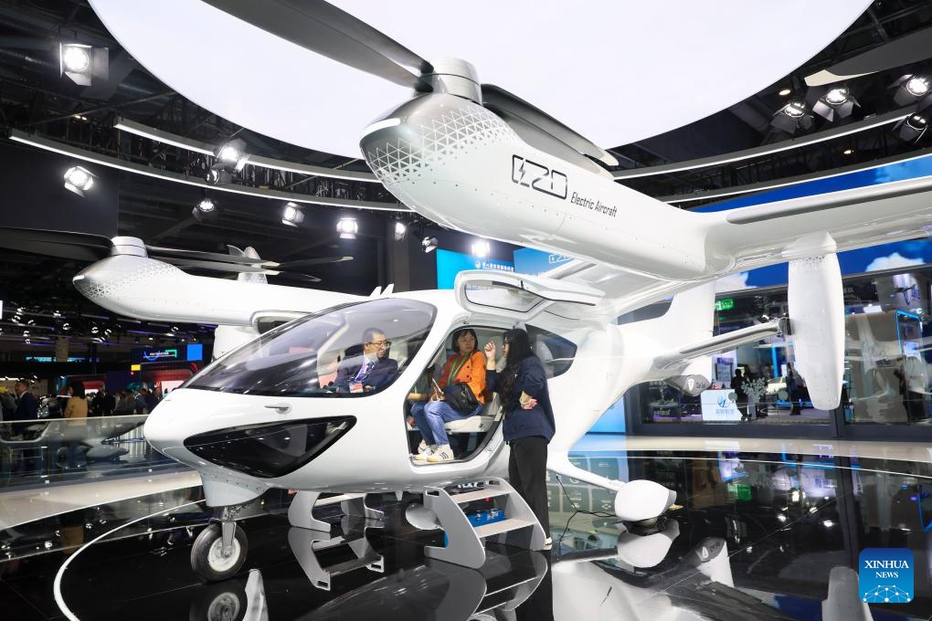 Visitors try an electric vertical takeoff and landing aircraft at the booth of TCab Tech at the Automobile and Smart Mobility exhibition area of the eighth China International Import Expo (CIIE) in east China's Shanghai, Nov. 8, 2025. The eighth CIIE showcased a range of new mobility products and innovative technologies, unfolding a diversified and multi-dimensional vision of future transportation. (Xinhua/Wang Xiang)