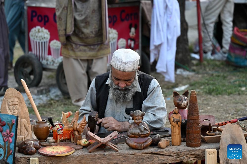 An artist processes wooden handicrafts during the Lok Mela Festival in Islamabad, capital of Pakistan, Nov. 7, 2025. The annual ten-day folk festival kicked off here on Friday. (Photo by Ahmad Kamal/Xinhua)