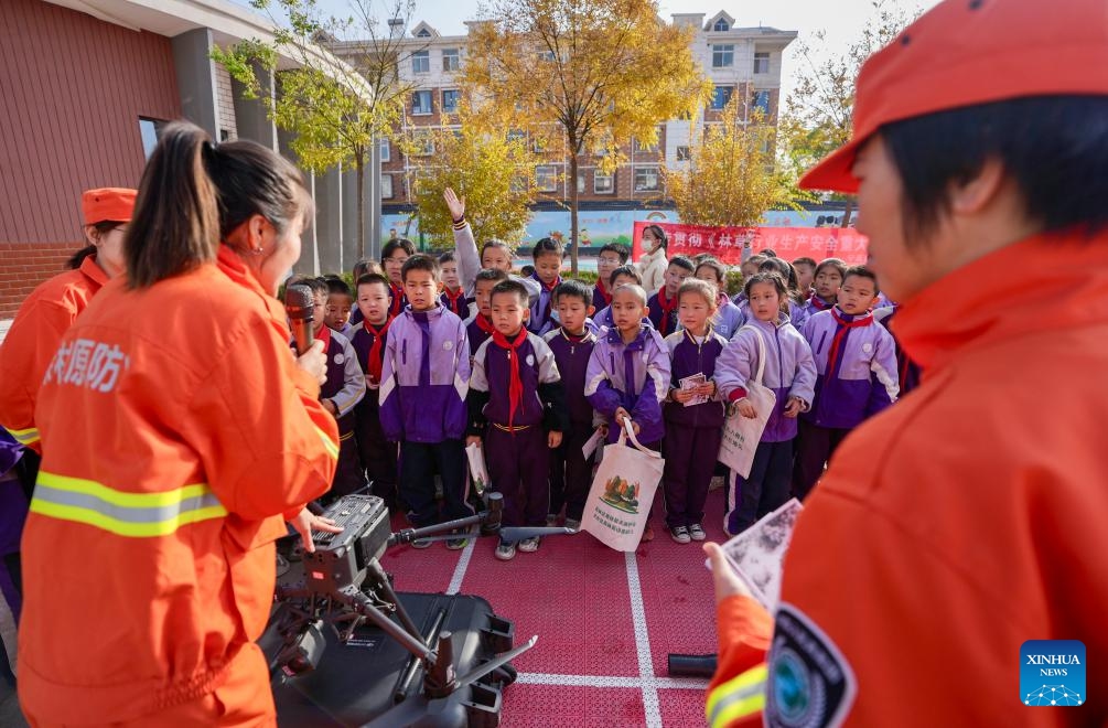 Staff members of Ningxia Helan Mountain National Nature Reserve Administration introduce equipment for forest fire prevention to students at a primary school in Yinchuan, northwest China's Ningxia Hui Autonomous Region, Nov. 7, 2025. Currently, the risk of forest fire is high across the Helan Mountain. Staff members of local nature reserve administration have rolled out a series of educational activities with the theme of forest fire prevention, aiming to enhance students' safety awareness via lectures, equipment demonstrations, and hands-on experiences. (Xinhua/Yang Zhisen)