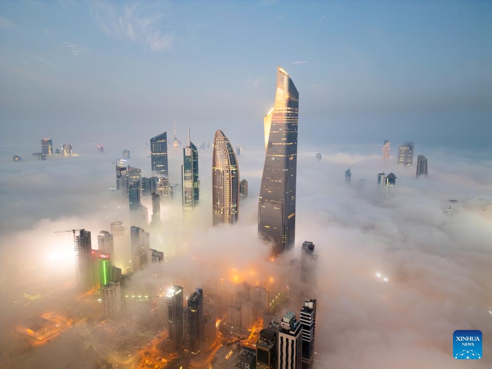 An aerial drone photo taken on Nov. 9, 2025 shows buildings shrouded in fog in Kuwait City, Kuwait. (Photo by Asad/Xinhua)