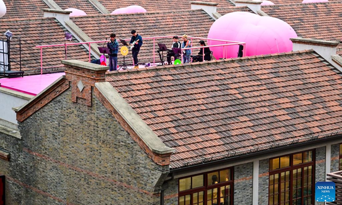 A band performs on a rooftop stage at a fashion landmark district in east China's Shanghai, Nov. 9, 2025. In recent years, Shanghai has focused on optimizing historical and cultural districts, developing urban cultural lifestyle areas, enriching citizens' cultural lives, and promoting the deep integration of culture and tourism. (Xinhua/Cai Xiangxin)
