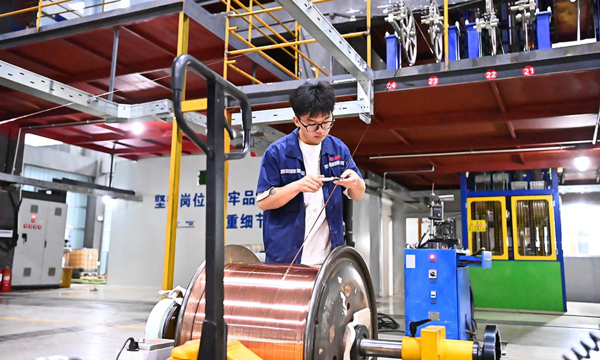 A worker makes electromagnetic wire products in an intelligent workshop in Chongren county, Fuzhou, East China's Jiangxi Province, on November 10, 2025. The county has expanded its copper processing industry in recent years and adopted the 