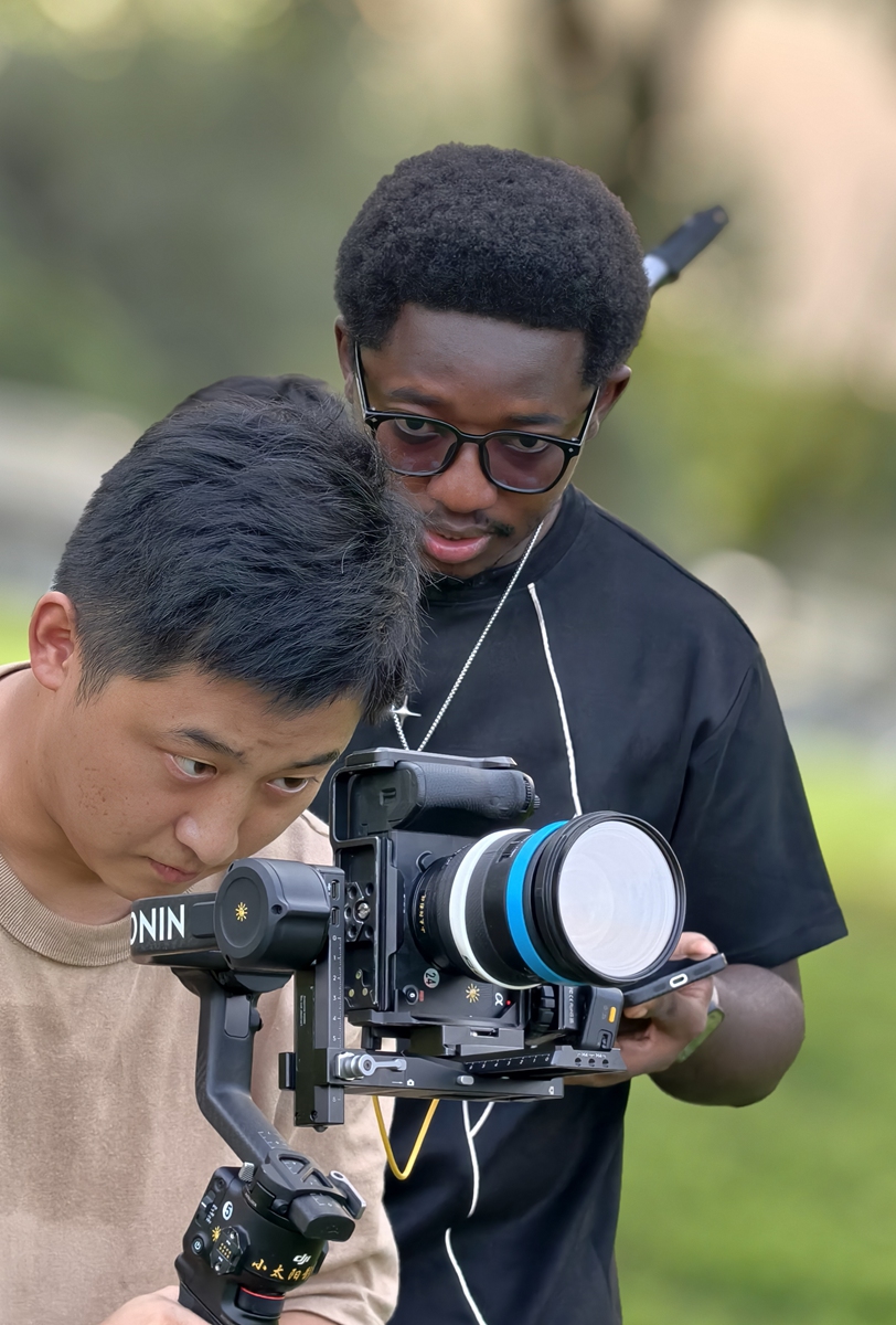 Kawawa Kadichi (right)discusses shooting ideas with a Chinese photographer on the set of a variety show on September 3, 2025. Photo: Courtesy of Kadichi