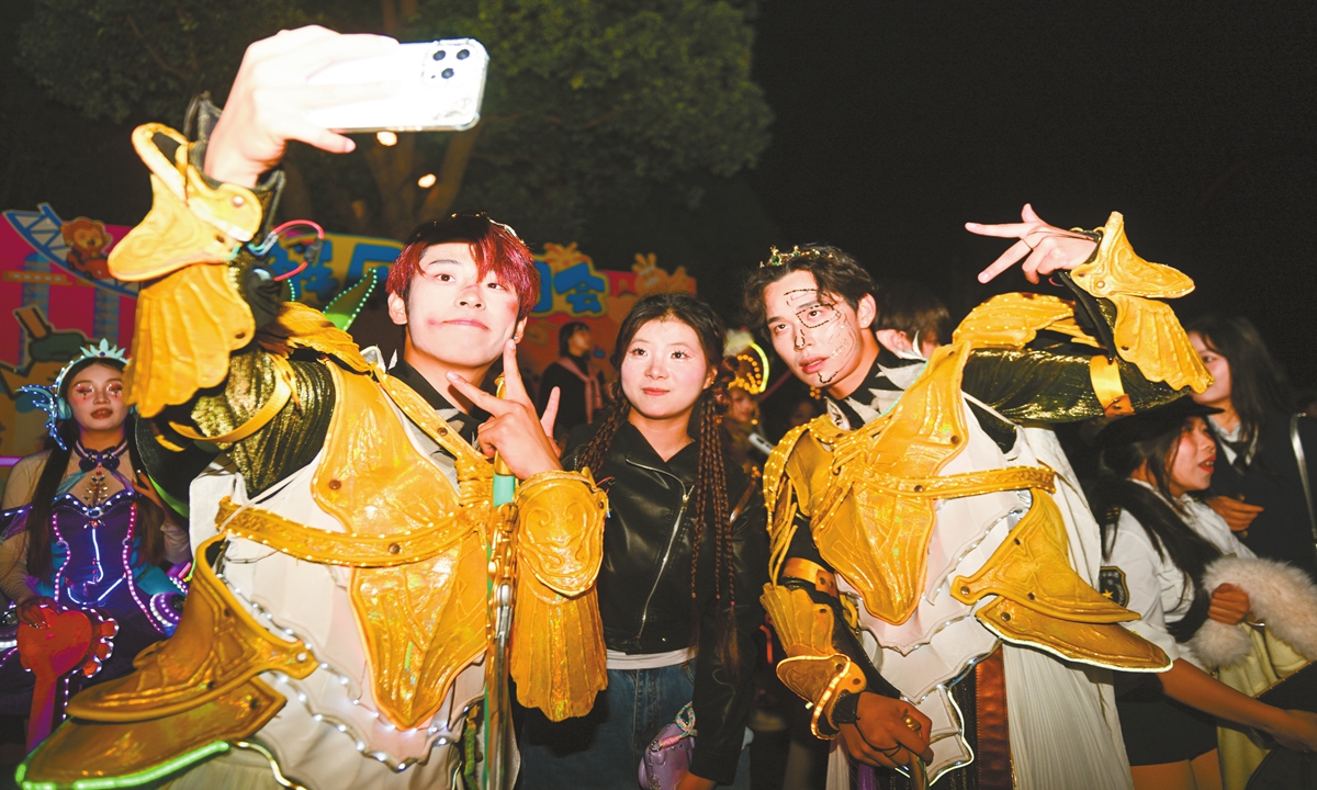 A tourist takes photos with two cosplayed staffs during an event at a theme park in Suzhou, East China's Jiangsu province, on November 1, 2025. Photo: VCG